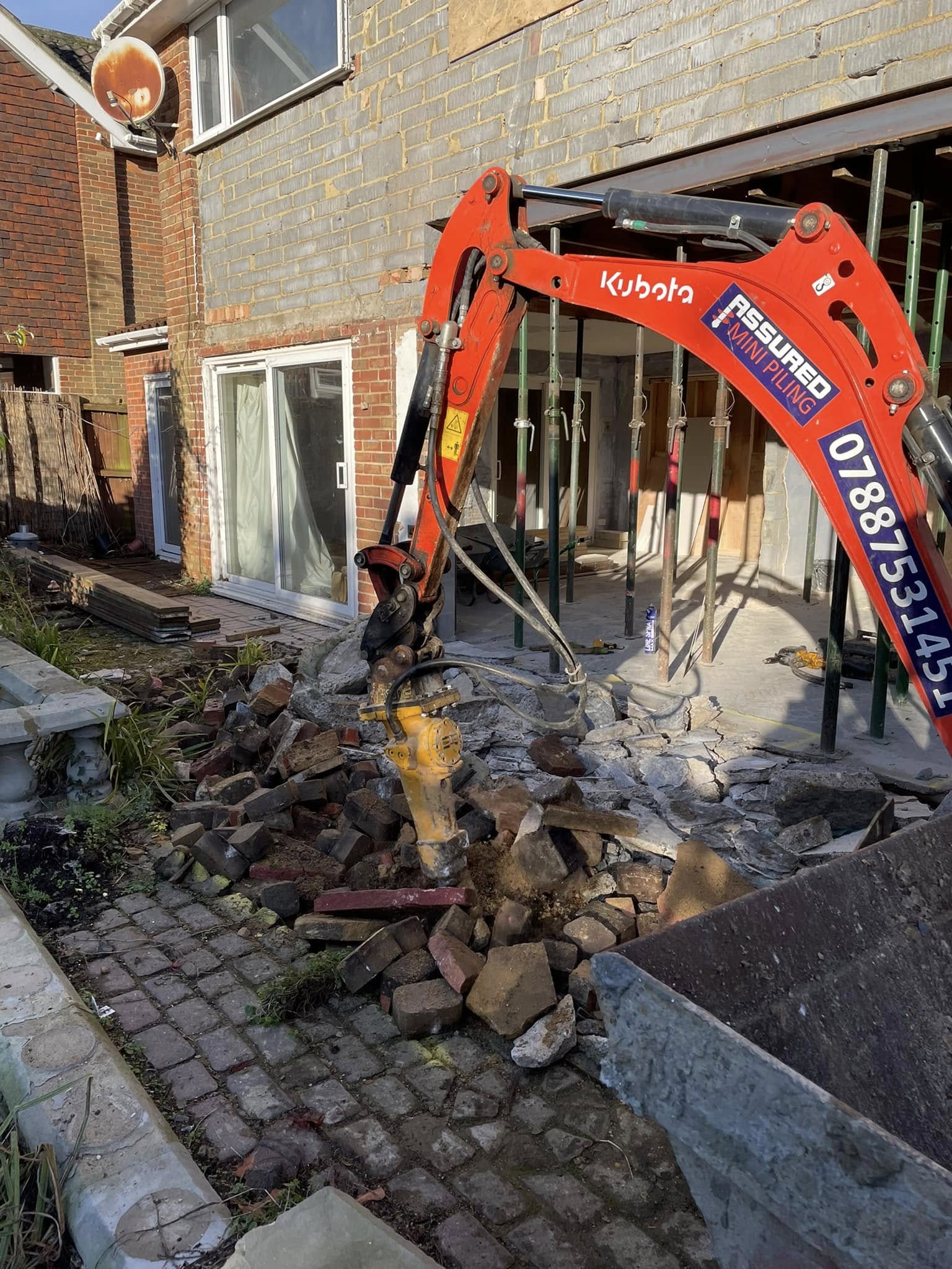 Drill attachment on digger digging up cobble patio in Basildon | Essex | Kent | London | Hertfordshire